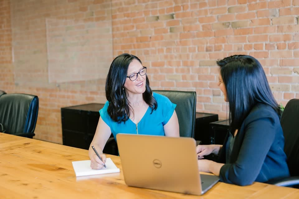 Two colleagues talking across a desk