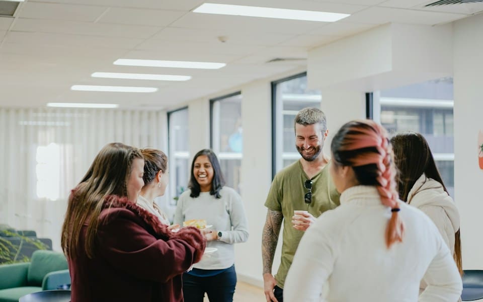 A group of colleagues chatting together in a bright office