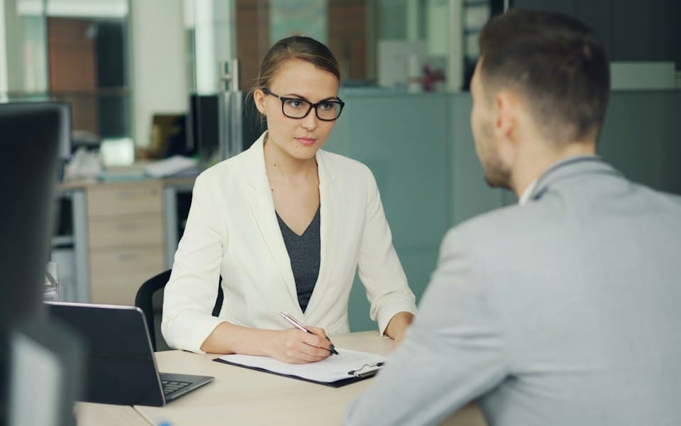 A manager interviewing a candidate across a desk