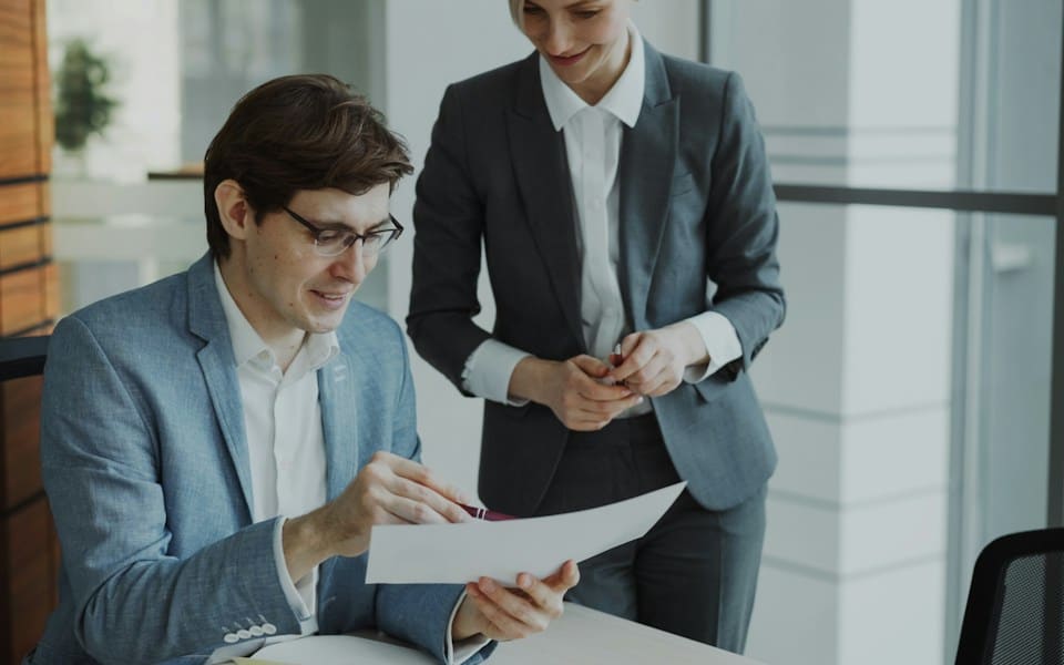 Two colleagues going over a printed document together