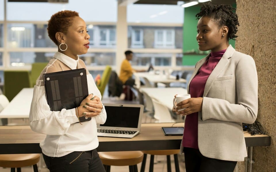 Two colleagues in conversation in an open office