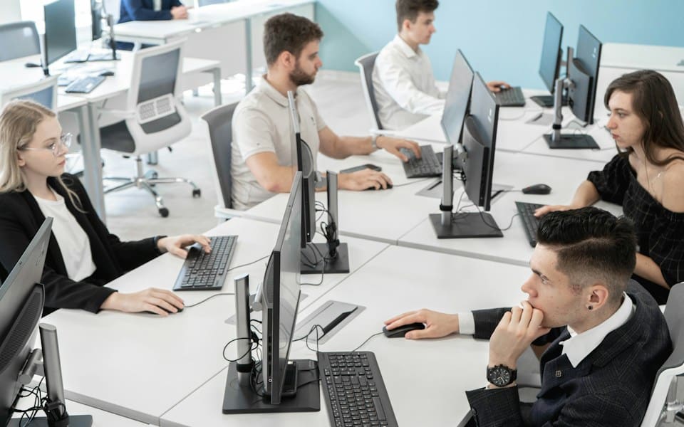 A team working at their monitors in a bright open office